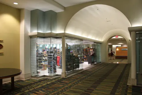 Glass-fronted retail shop along an arched corridor at Ala Moana Hotel.