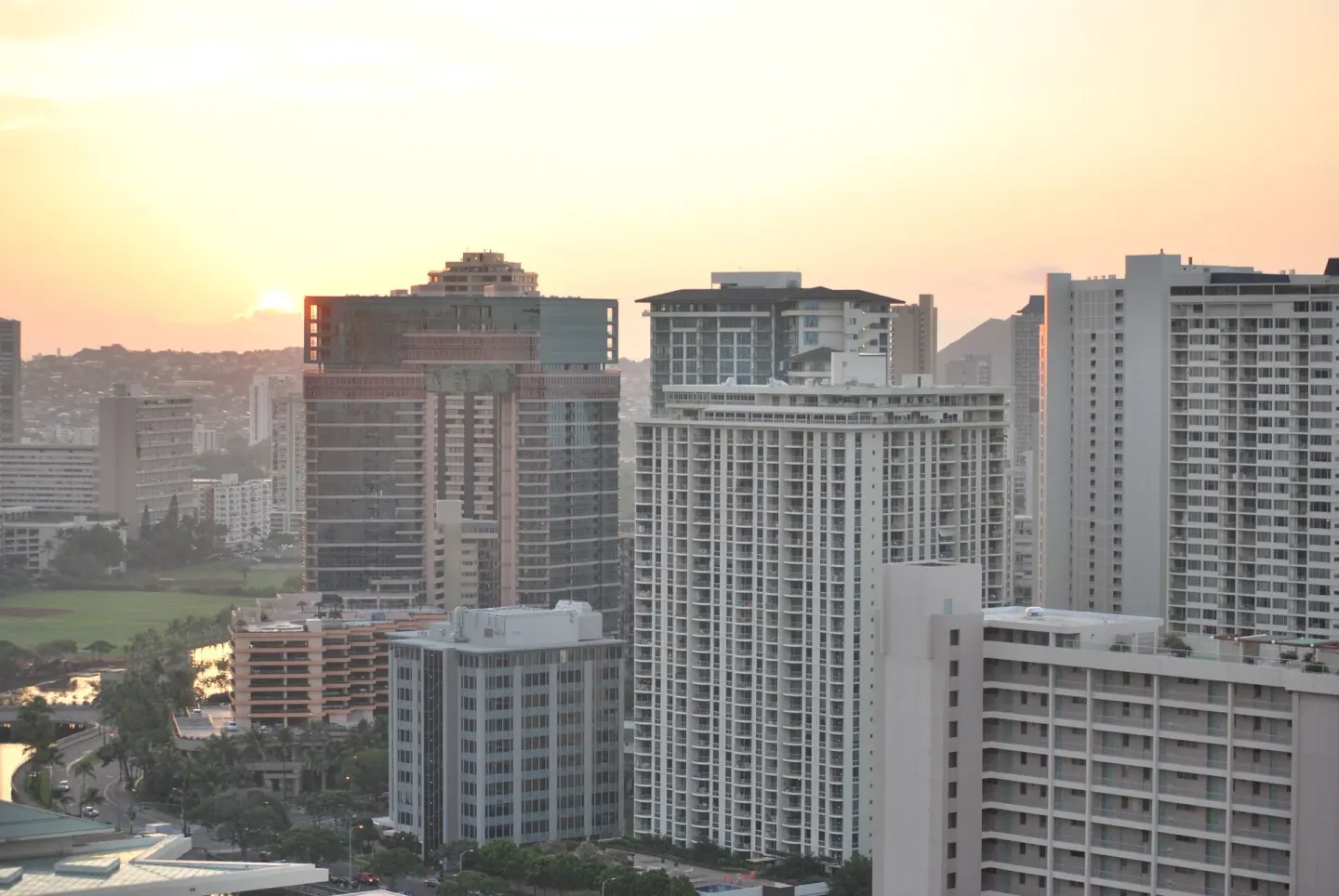 Sunset city skyline view from Ala Moana Hotel with high-rise buildings and warm sky.
