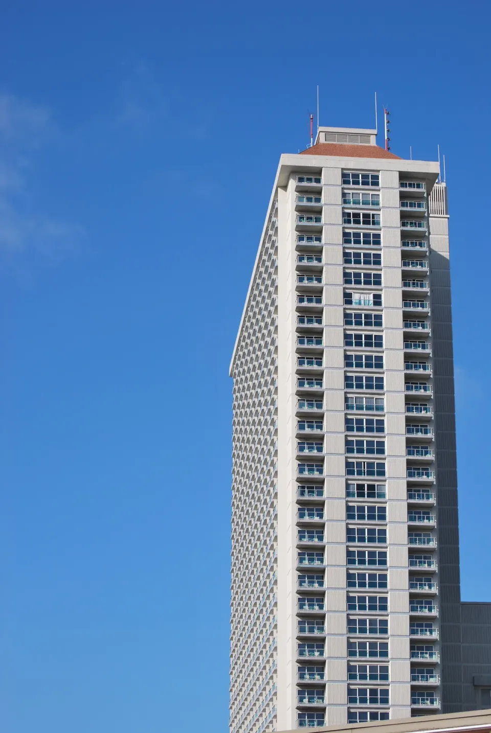 Upper floors of Ala Moana Hotel tower against a clear blue sky.