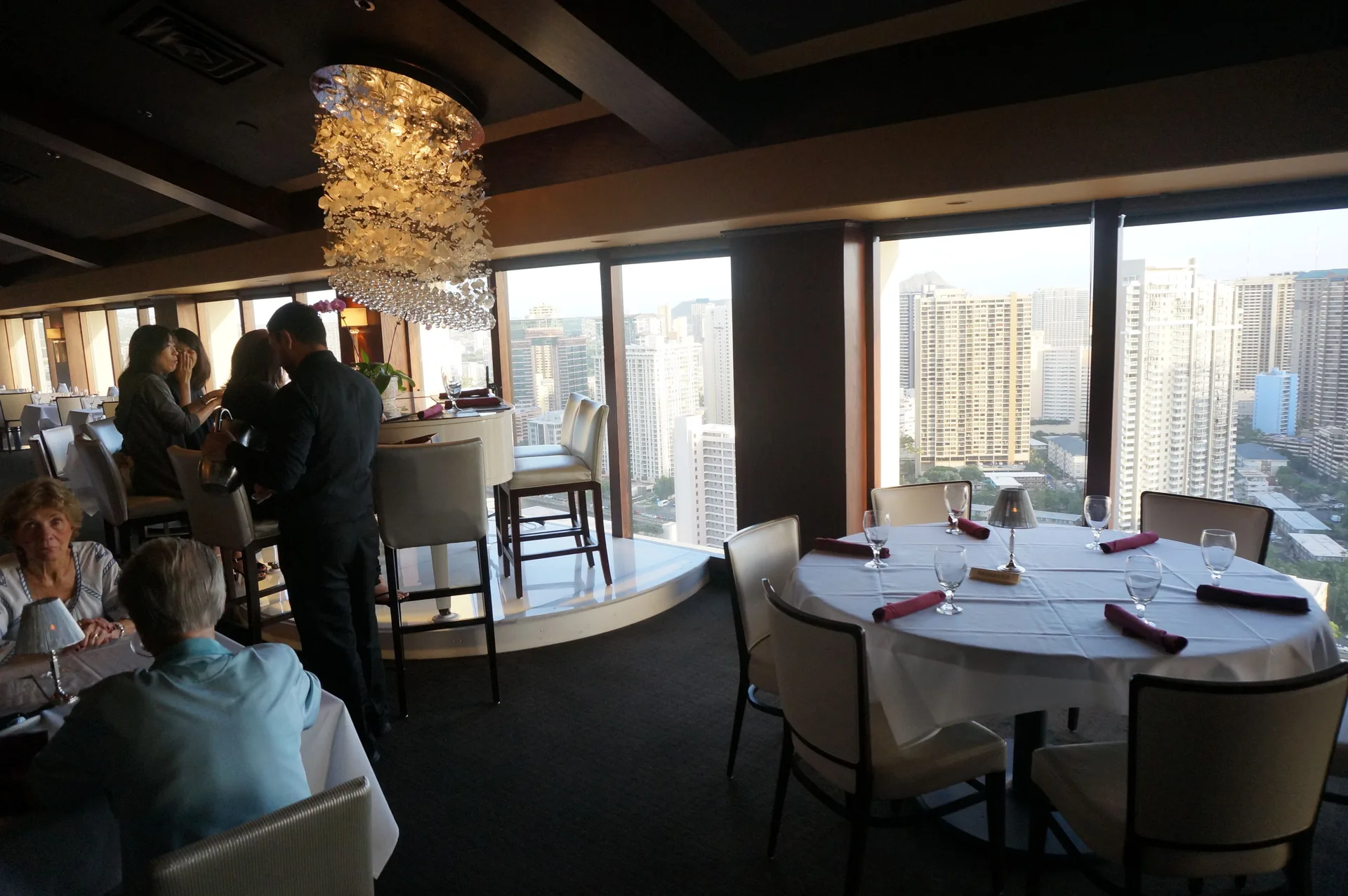 Signature Prime Steak & Seafood at Ala Moana Hotel with round tables and high-rise city views.