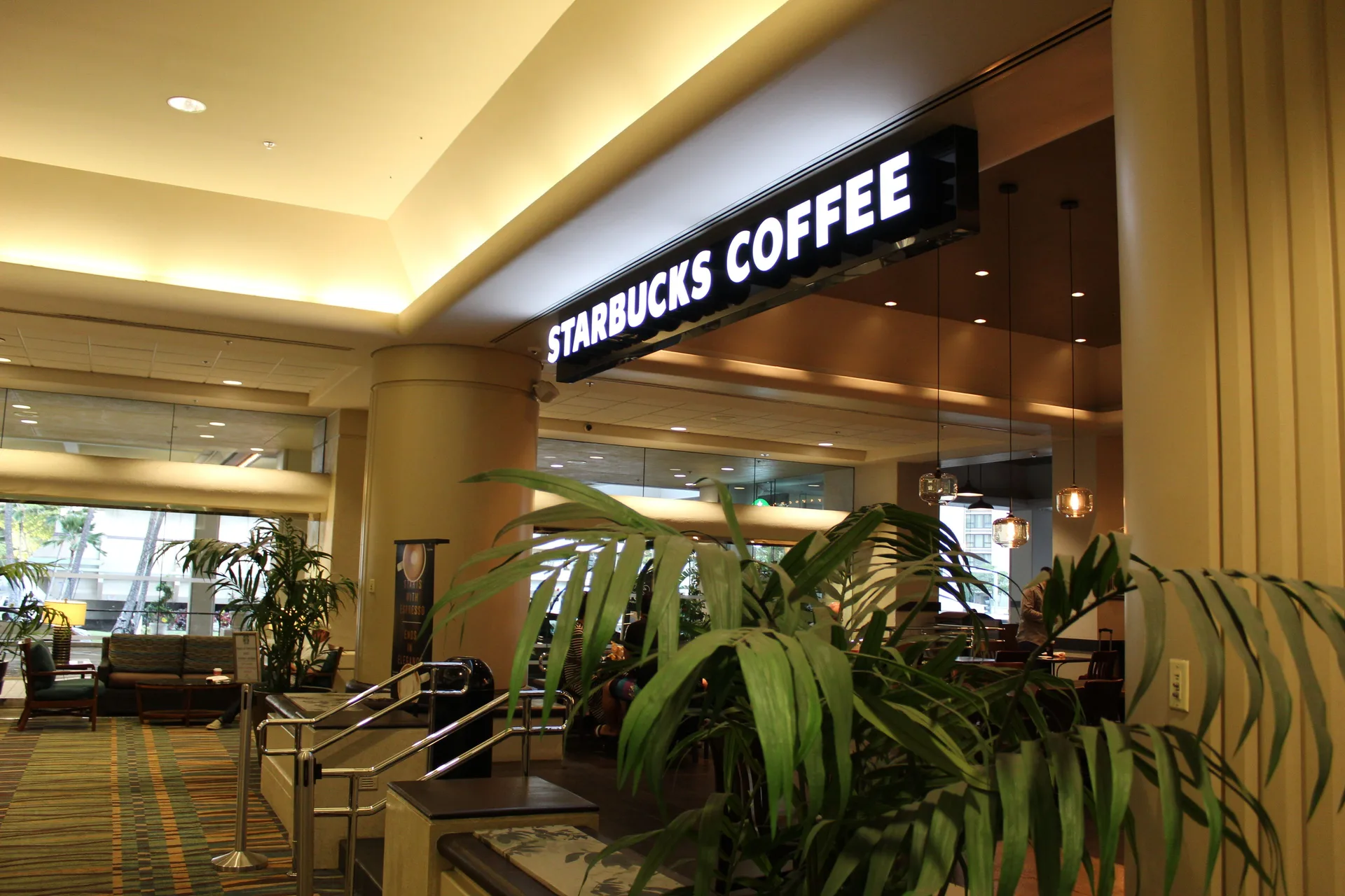 Starbucks Coffee entrance with lobby seating and plants at Ala Moana Hotel.
