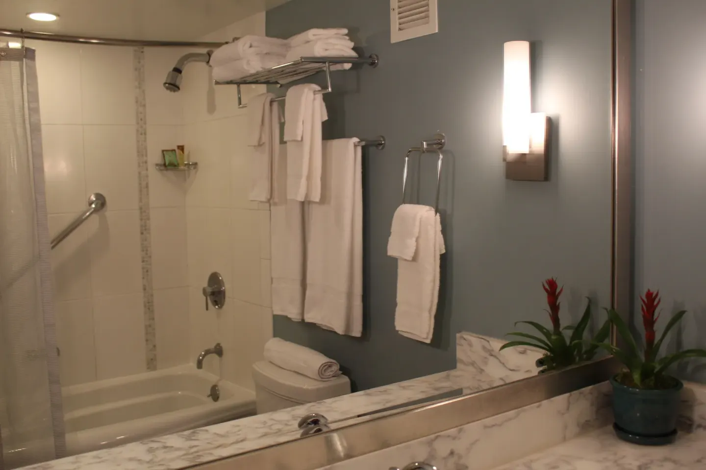 Standard Room bathroom with tub shower, towels, and vanity mirror at Ala Moana Hotel.