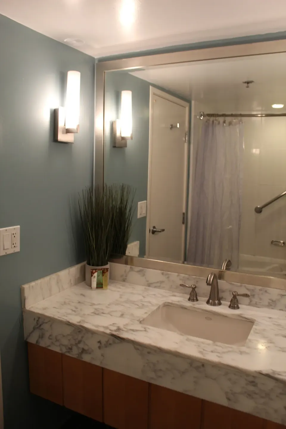 Standard Room bathroom vanity with marble-look counter and large mirror at Ala Moana Hotel.