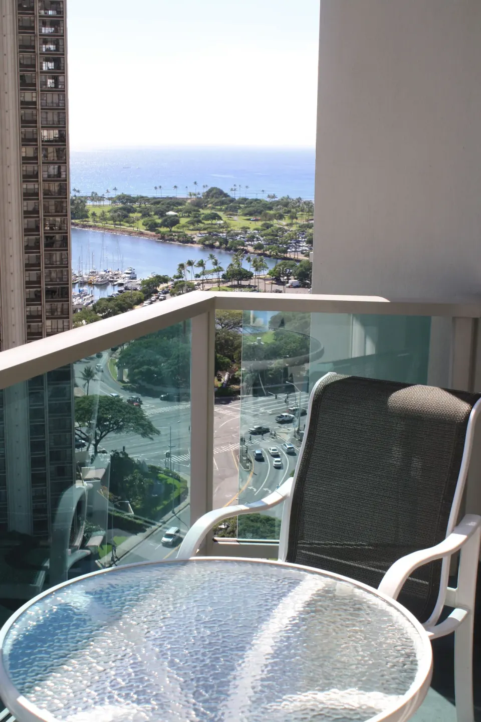 Balcony seating with an ocean, marina, and park view from Ala Moana Hotel.