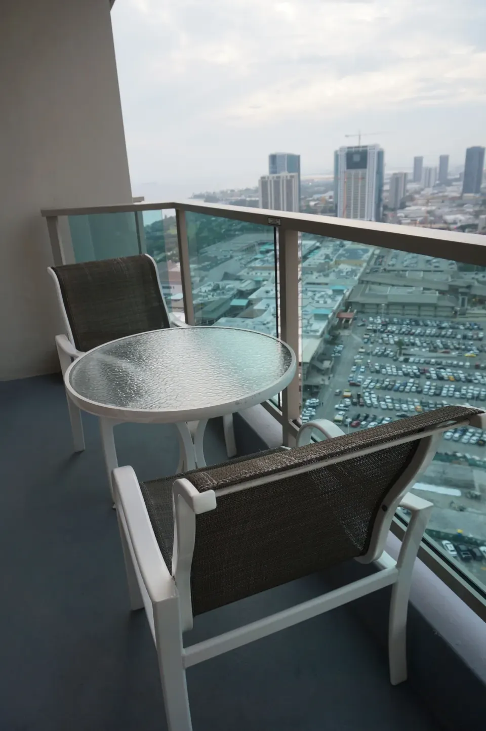 Superior Room balcony chairs and round table with city view at Ala Moana Hotel.
