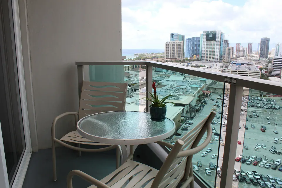 Superior Room balcony table with two chairs and skyline view at Ala Moana Hotel.