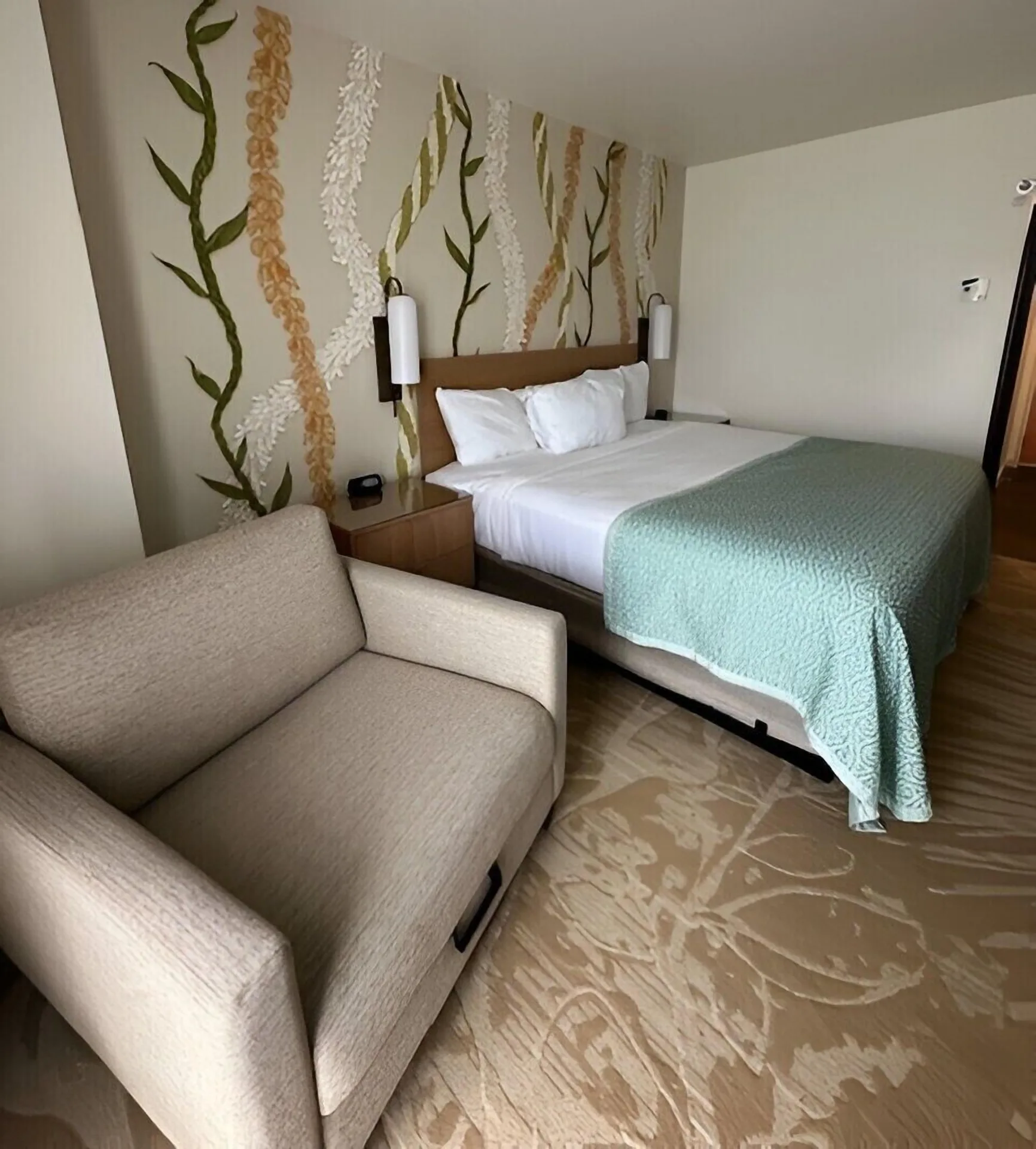 Superior Room bed with teal coverlet and armchair at Ala Moana Hotel.