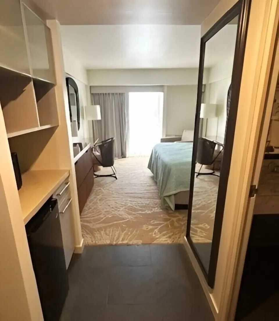Superior Room entry with bed, mirror, shelves, and mini fridge at Ala Moana Hotel.