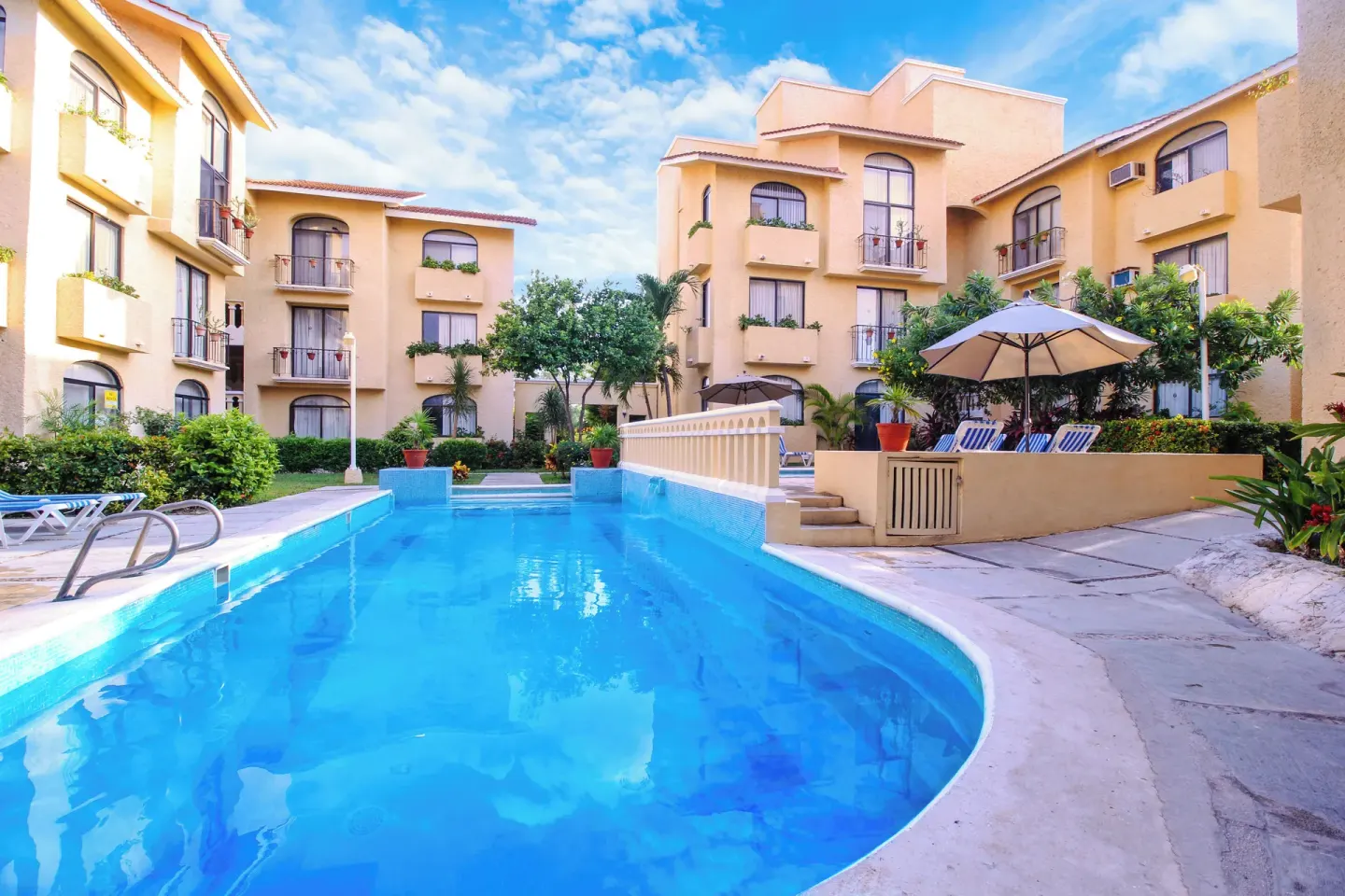 Courtyard pool surrounded by guest buildings at All Ritmo Cancun Resort & Water Park.