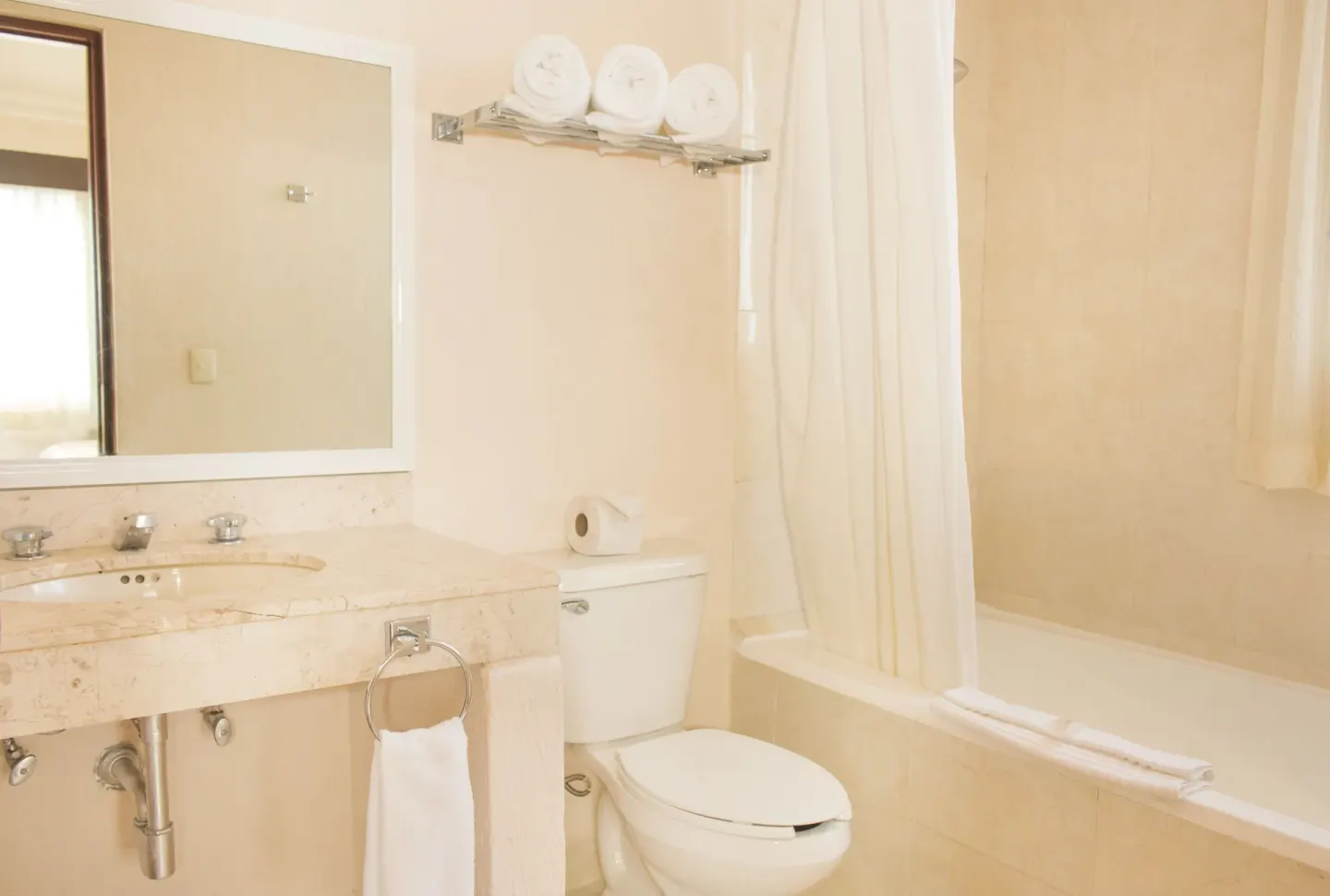 Guest bathroom with marble-style vanity, toilet, tub, and towel rack at All Ritmo Cancun Resort & Water Park.