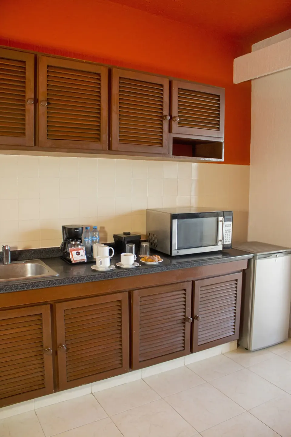 Guest room kitchenette with sink, coffee maker, microwave, and mini fridge at All Ritmo Cancun Resort & Water Park.