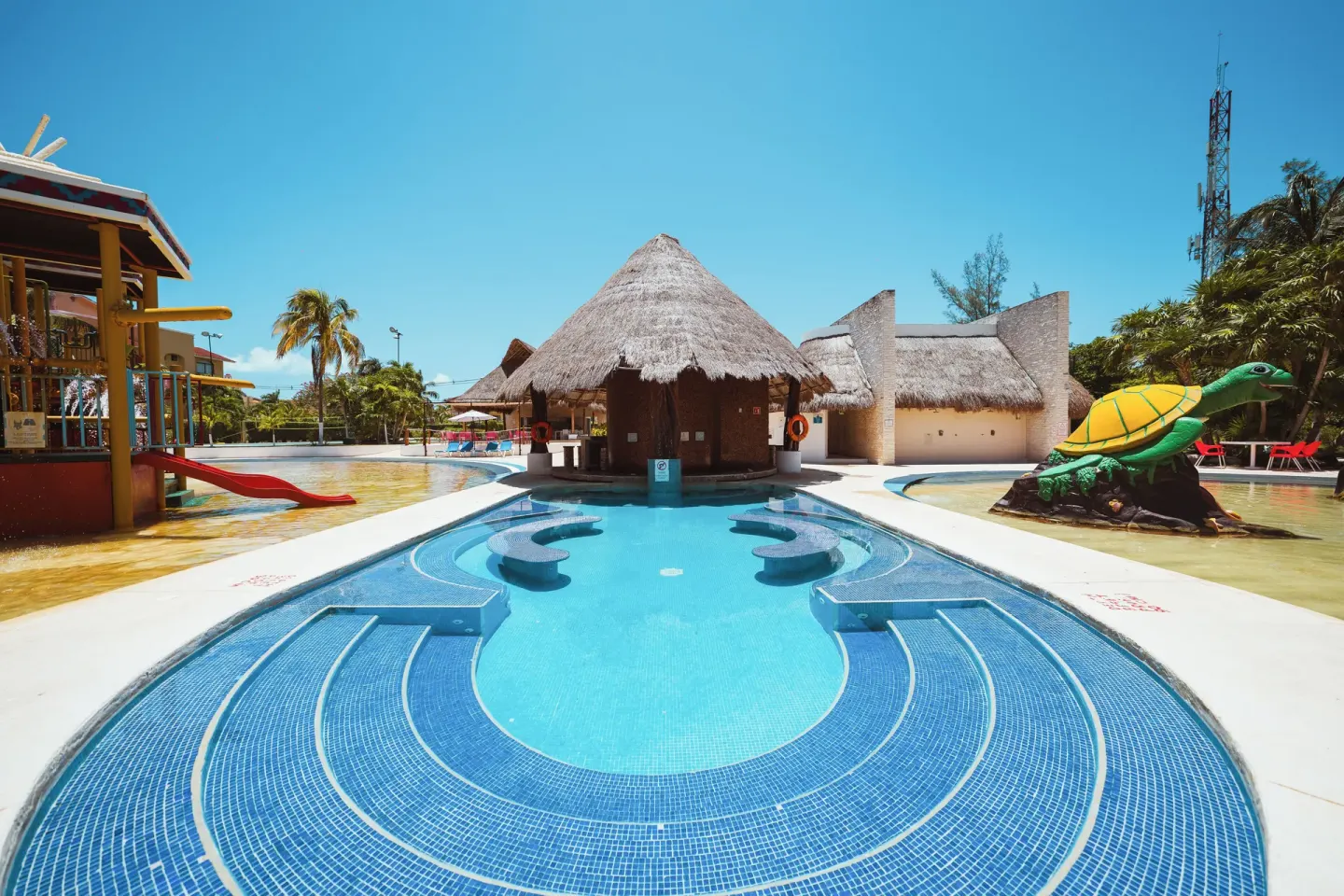 Water park pool with thatched hut and turtle figure at All Ritmo Cancun Resort & Water Park.