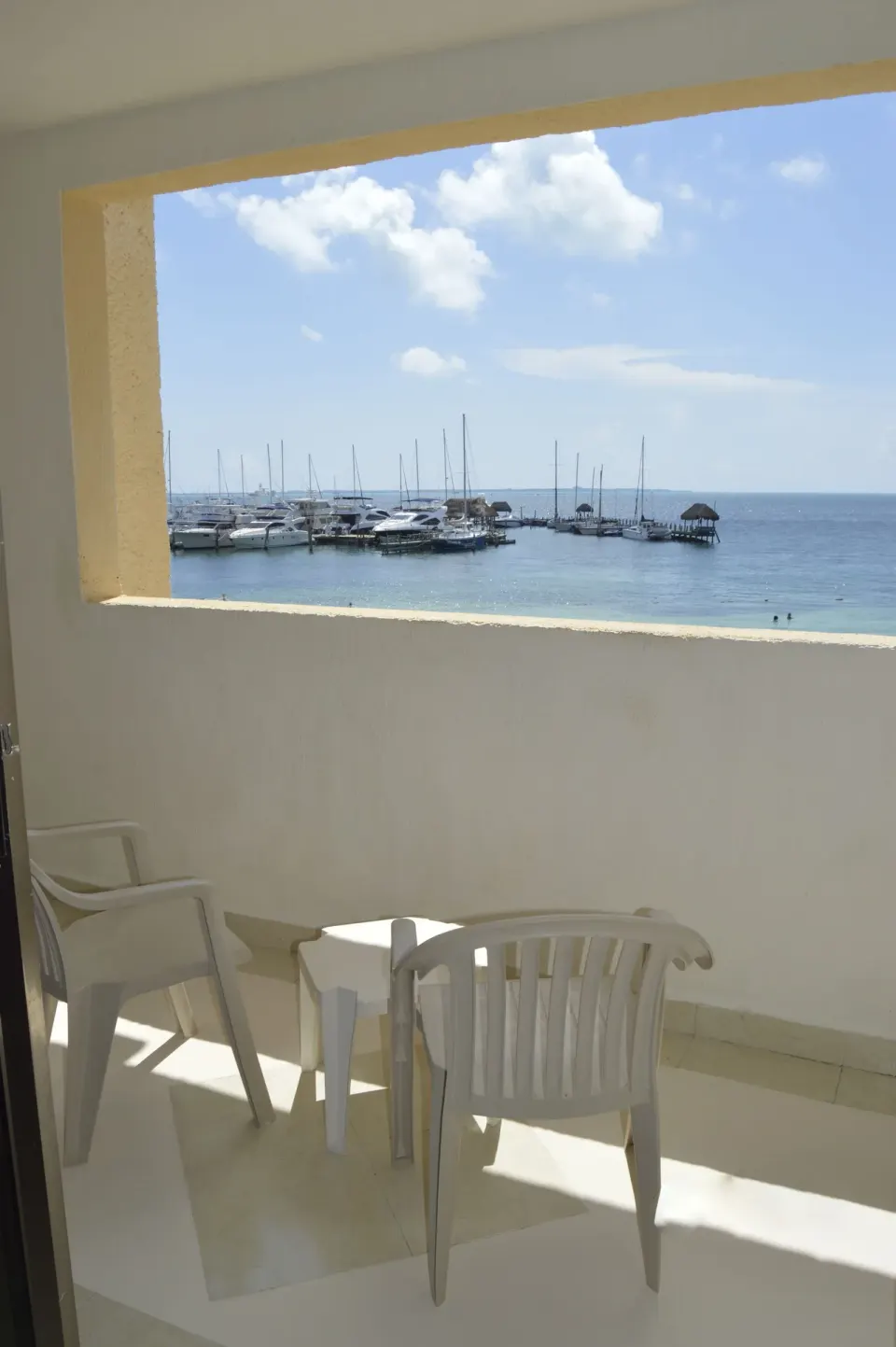 Sea-view balcony with chairs at All Ritmo Cancun Resort & Water Park overlooking marina and water.