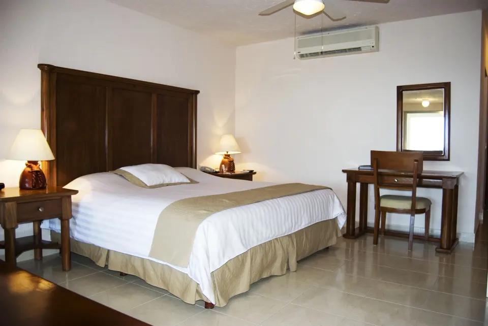 Standard room with one bed and writing desk at All Ritmo Cancun Resort & Water Park.