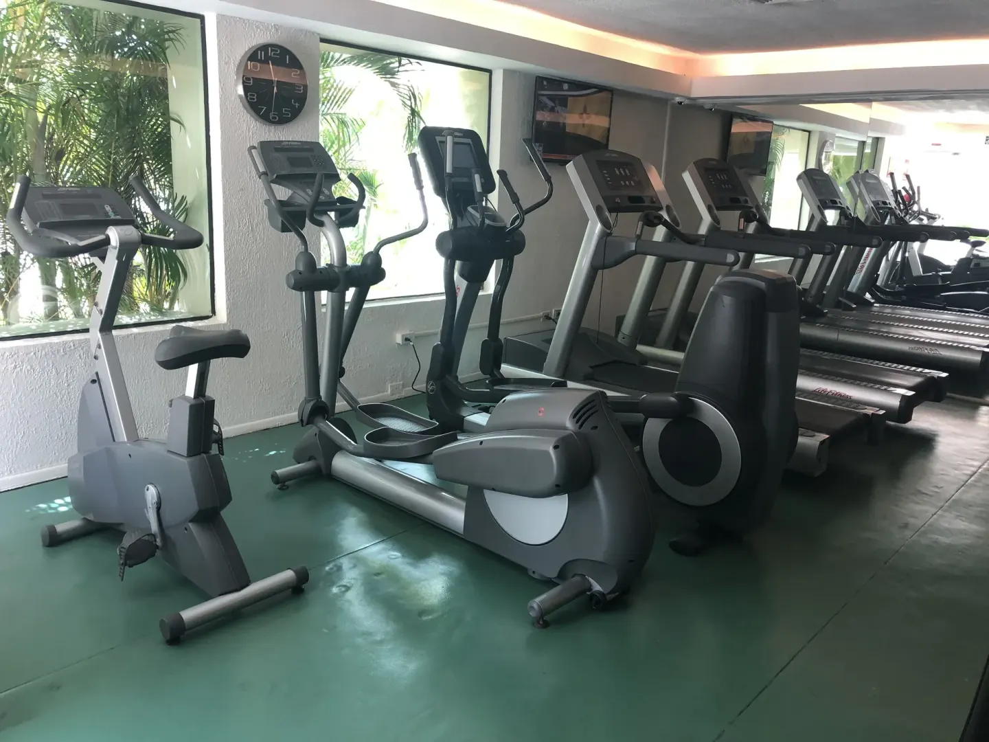 Fitness room with treadmills, bikes, and elliptical machines at Allegro Cozumel.