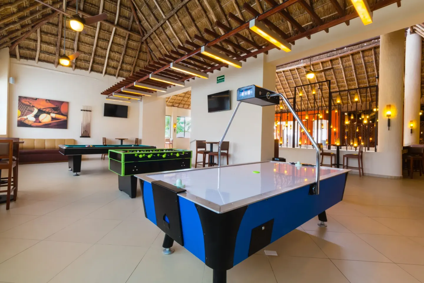 Game room with air hockey, foosball, and pool tables at Allegro Cozumel.
