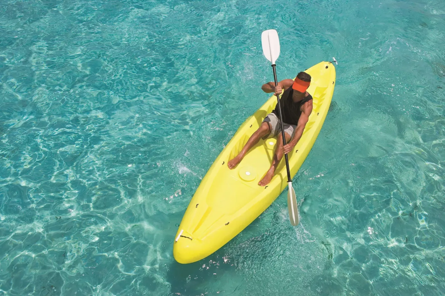 Guest paddling a yellow kayak over clear turquoise water at Allegro Cozumel.