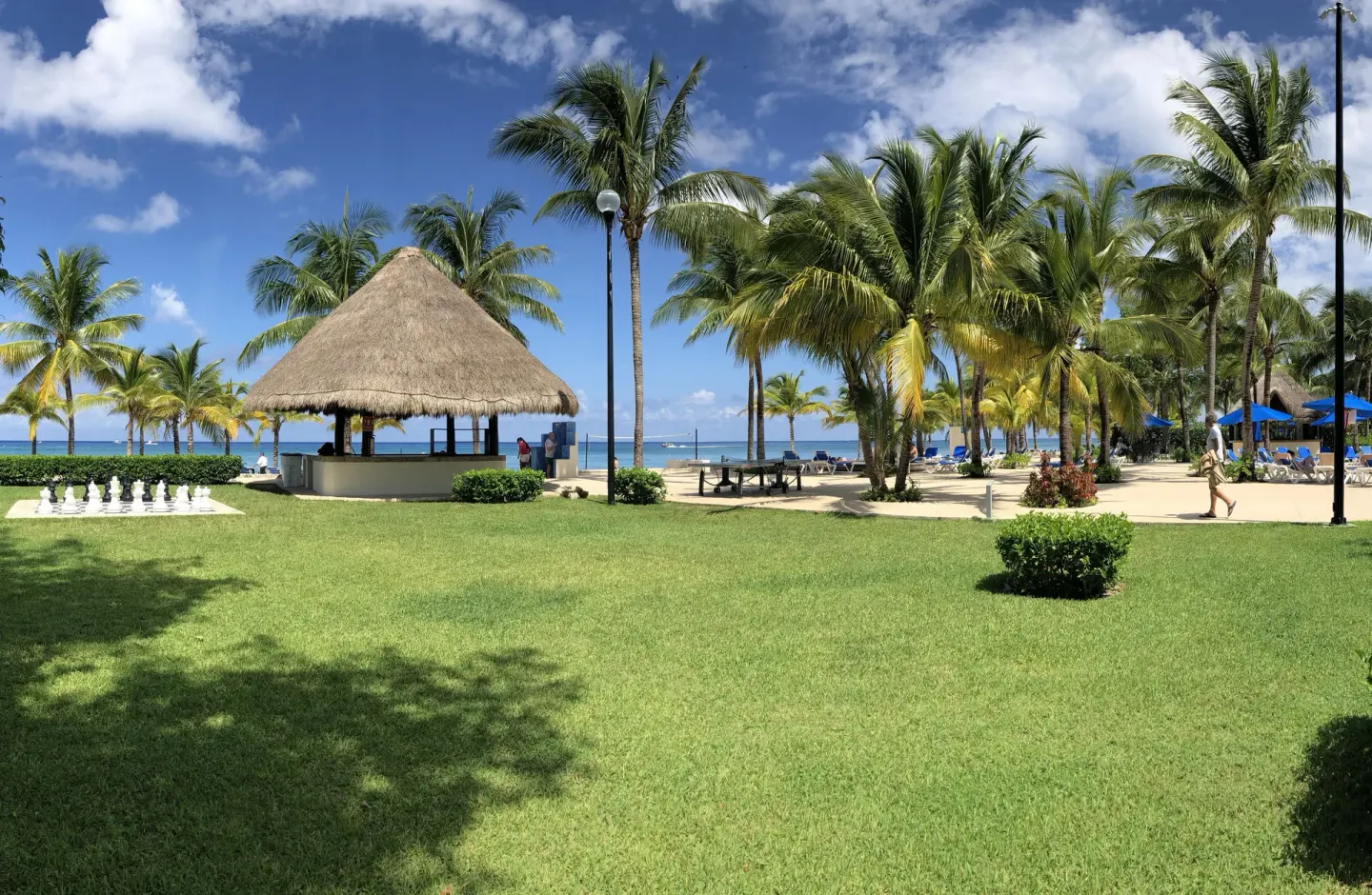 Palm lawn, thatched hut and oceanfront lounge area at Allegro Cozumel.