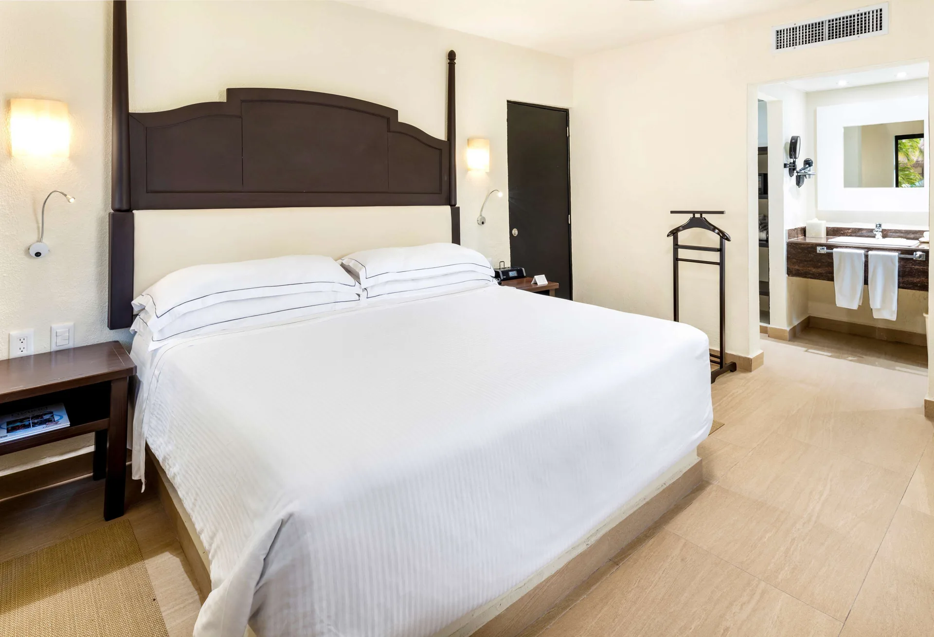 Premium Suite king bed with open vanity area beyond at Allegro Cozumel.