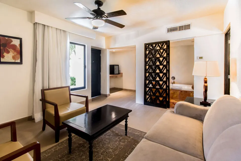 Premium Suite living room with sofa, chairs and bath area at Allegro Cozumel.