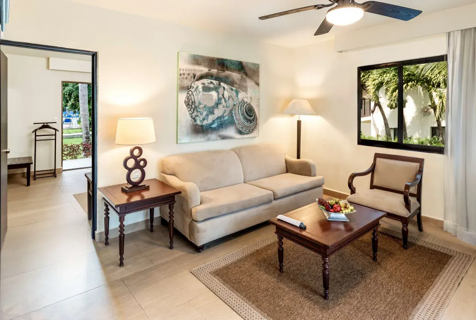 Premium Suite sitting area with sofa, coffee table and garden window at Allegro Cozumel.