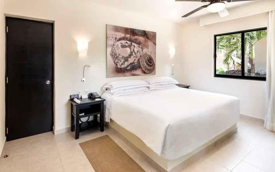 Superior Room with king bed, bedside table, and garden window at Allegro Cozumel.