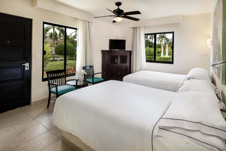 Superior Room with two beds, chairs, TV cabinet, and garden windows at Allegro Cozumel.