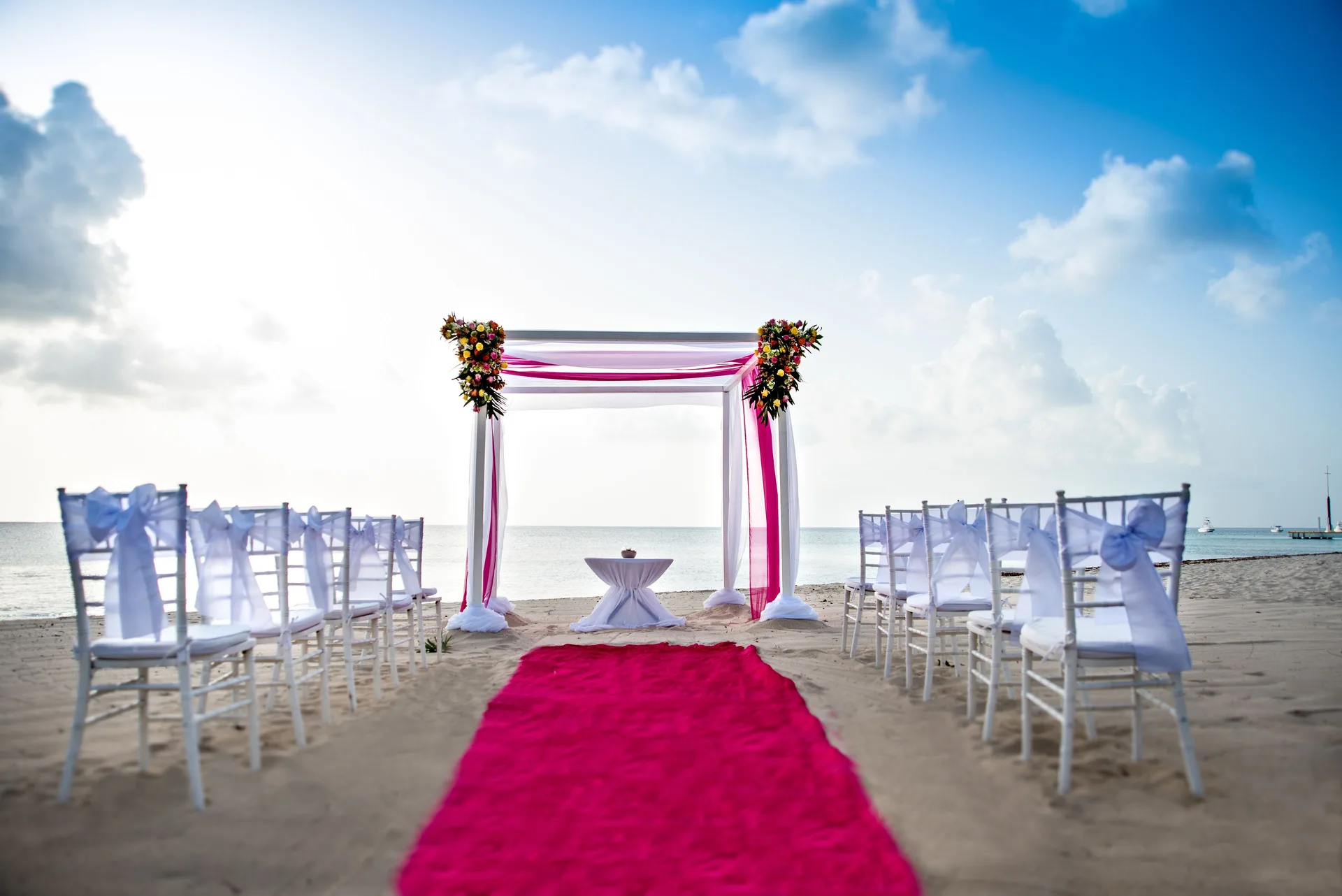 Beach wedding aisle and floral arch face the sea at Allegro Cozumel.