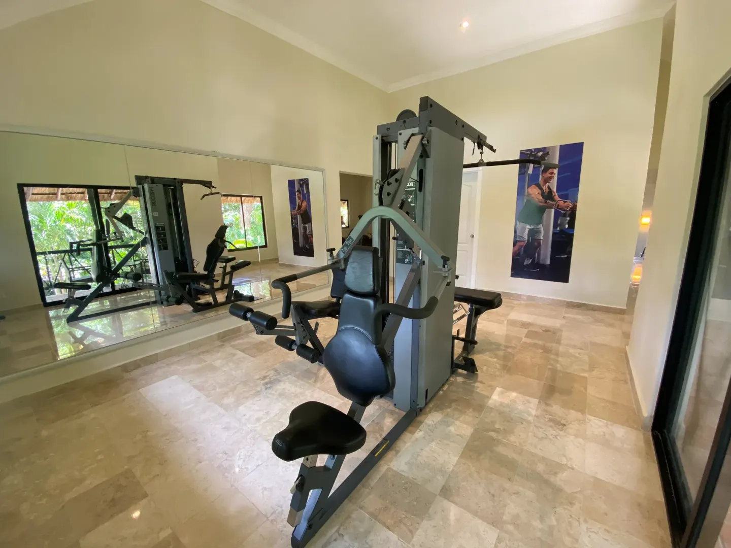 Exercise machines and wall mirrors are shown in the fitness room at Allegro Playacar.