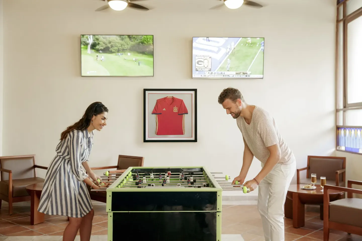 Guests play foosball in a lounge at Allegro Playacar.