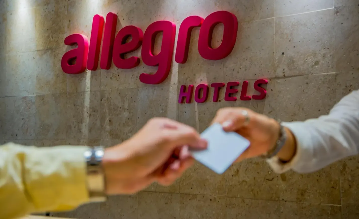 A guest receives a key card at the front desk at Allegro Playacar.
