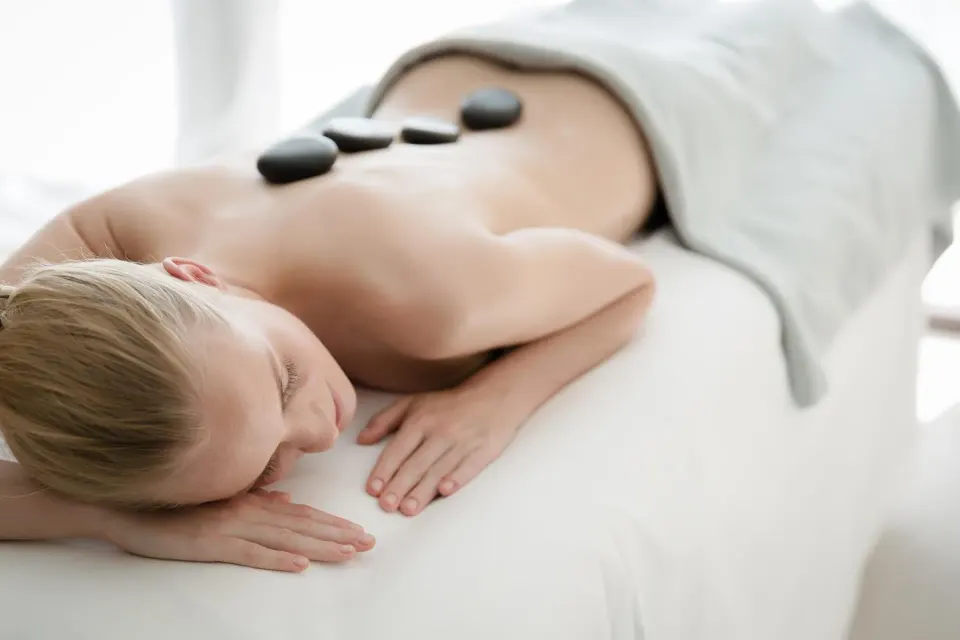 Spa guest resting with hot stones on their back at Allegro Playacar.