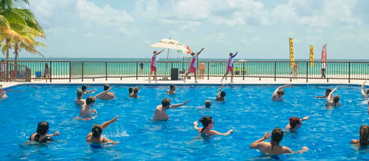 Guests follow a pool aerobics class by the beach at Allegro Playacar.