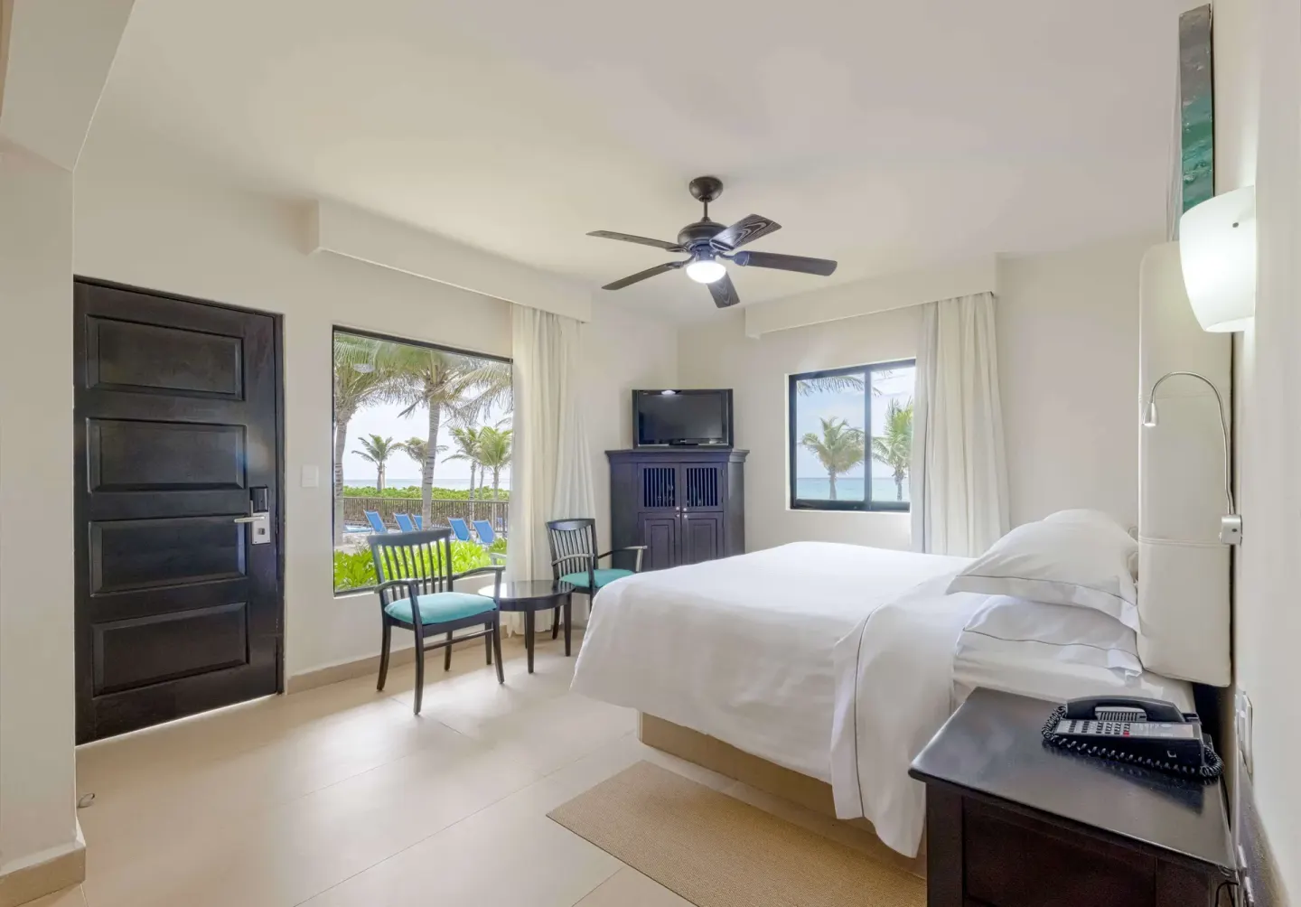 Premium Room with king bed, seating area, TV cabinet, and ocean-facing windows at Allegro Playacar.