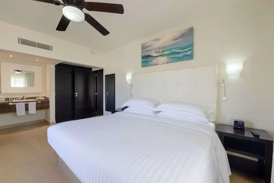 Superior Room with king bed, open vanity, and dark wardrobe at Allegro Playacar.