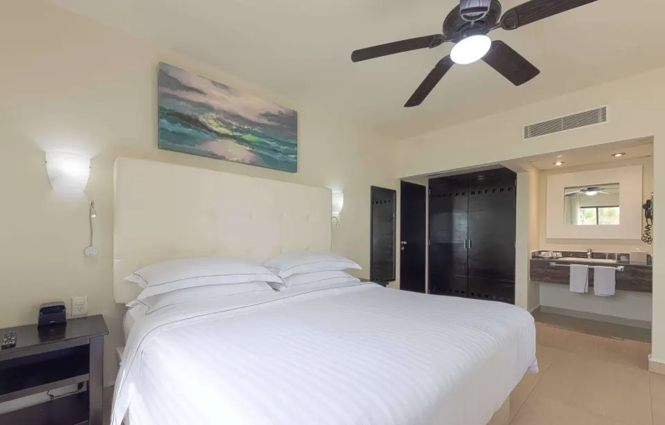 Superior Room king bed with vanity, wardrobe, and ceiling fan at Allegro Playacar.