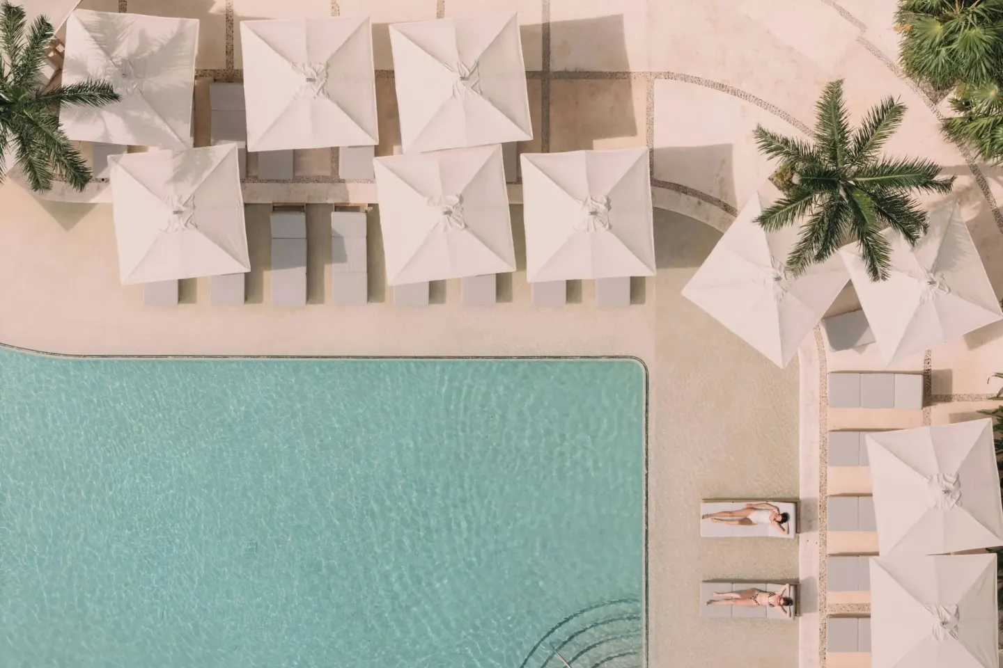 Overhead view of umbrellas, loungers, and pool edge at Almare, a Luxury Collection Resort, Isla Mujeres.
