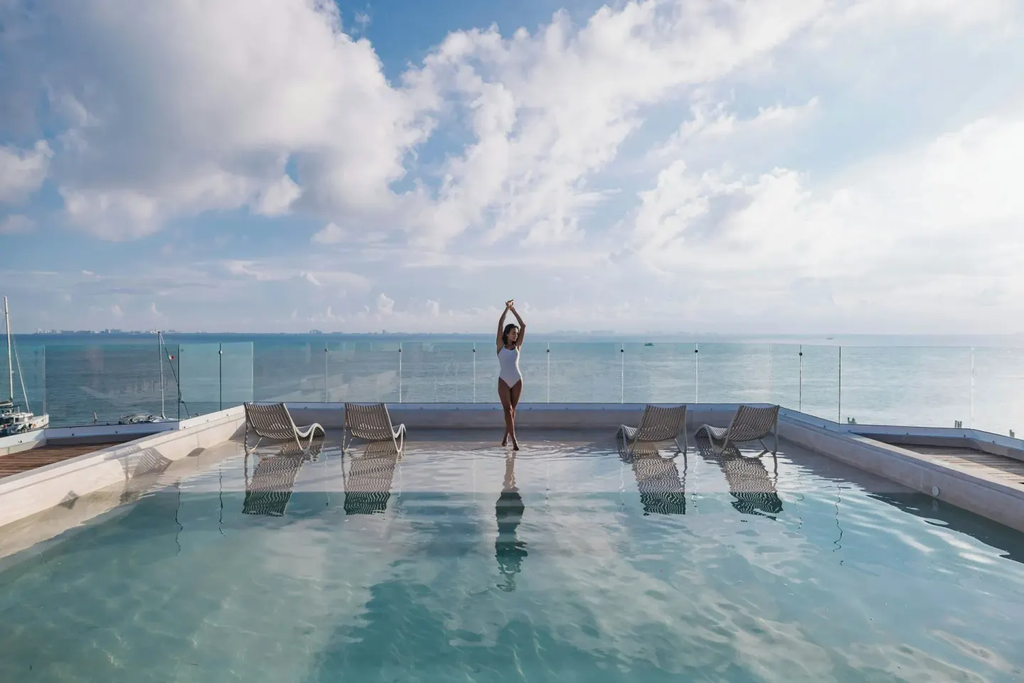 Rooftop pool with lounge chairs and open sea views at Almare, a Luxury Collection Resort, Isla Mujeres.