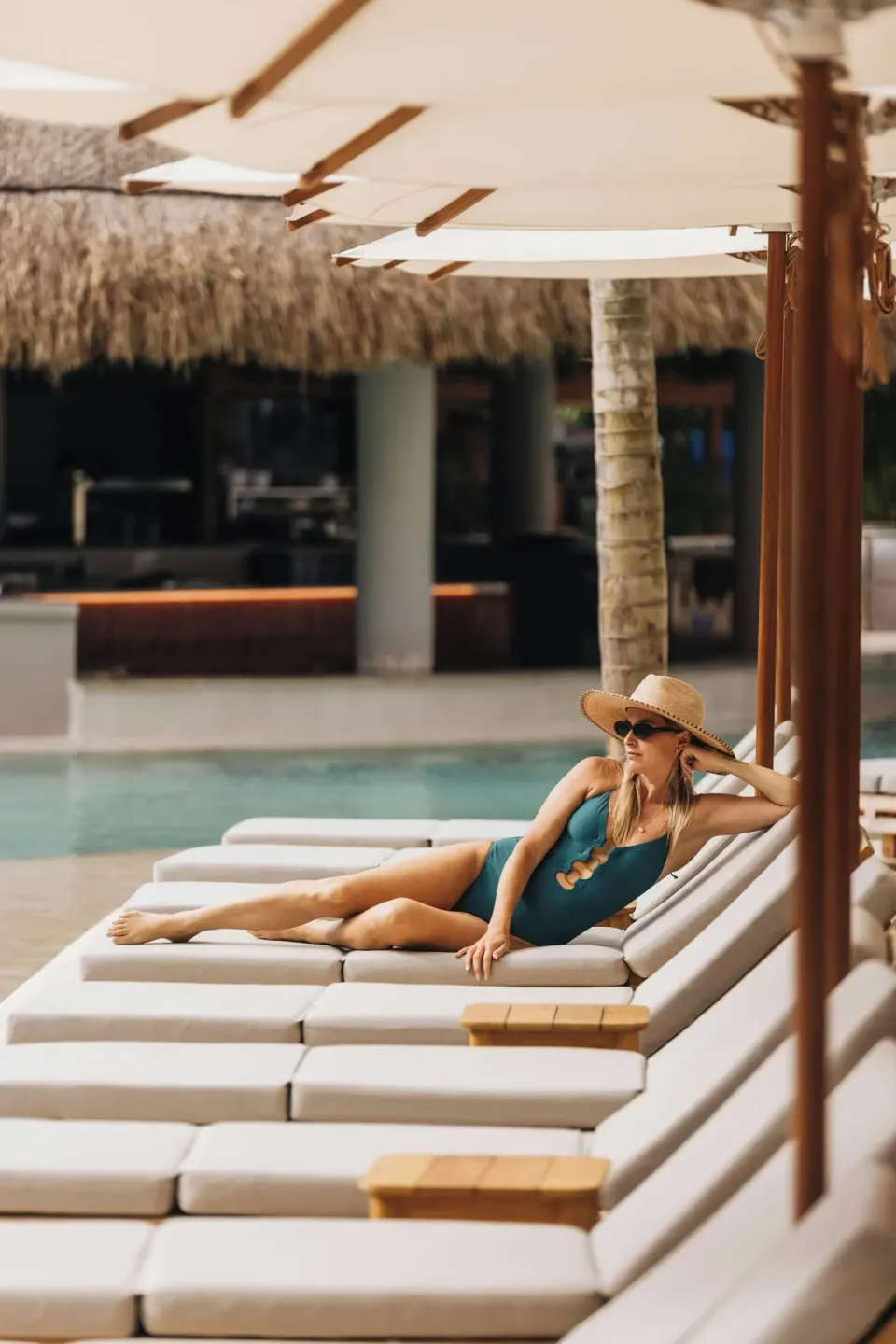 A guest relaxes on a shaded pool lounger at Almare, a Luxury Collection Resort, Isla Mujeres.