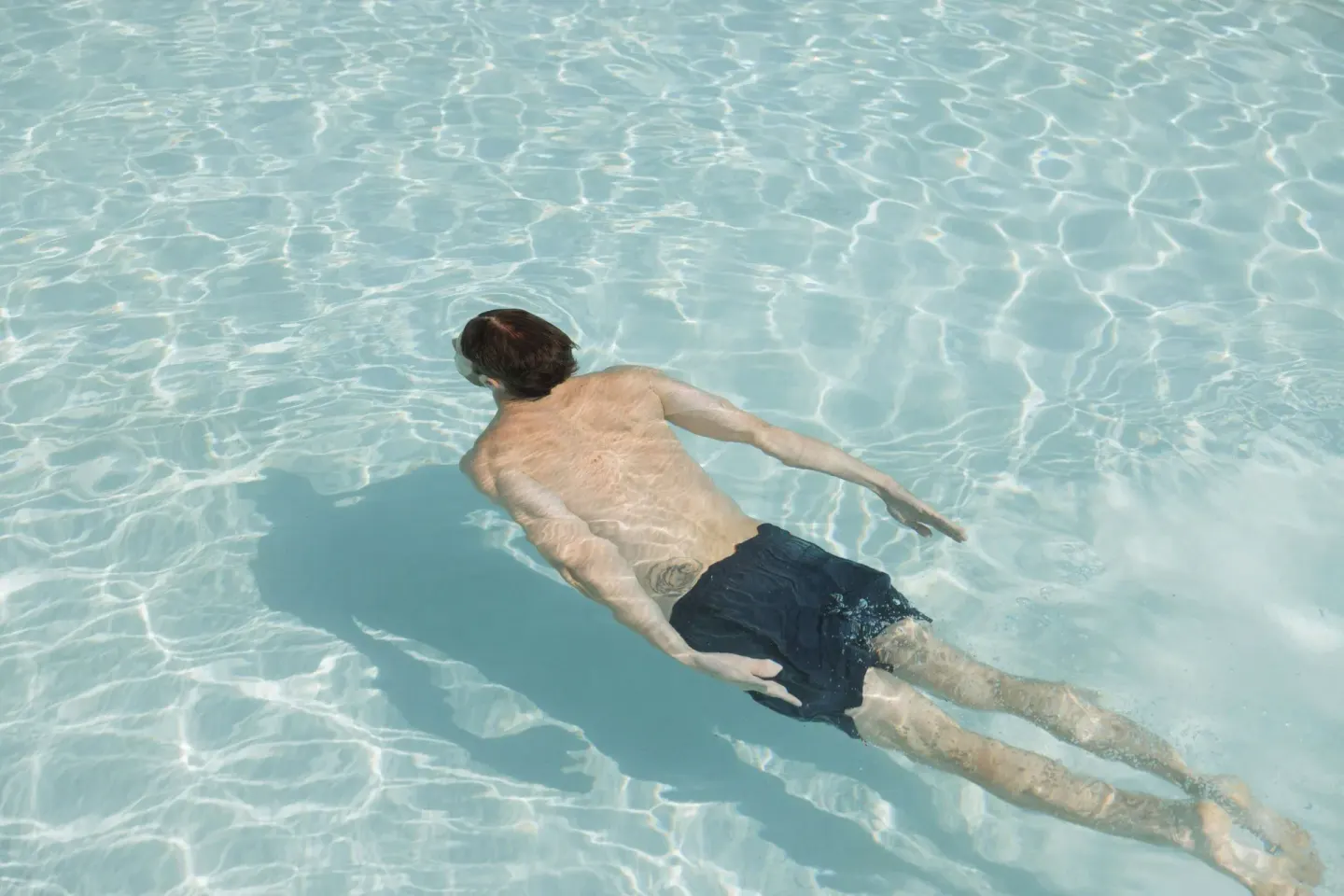A swimmer floats in clear pool water at Almare, a Luxury Collection Resort, Isla Mujeres.