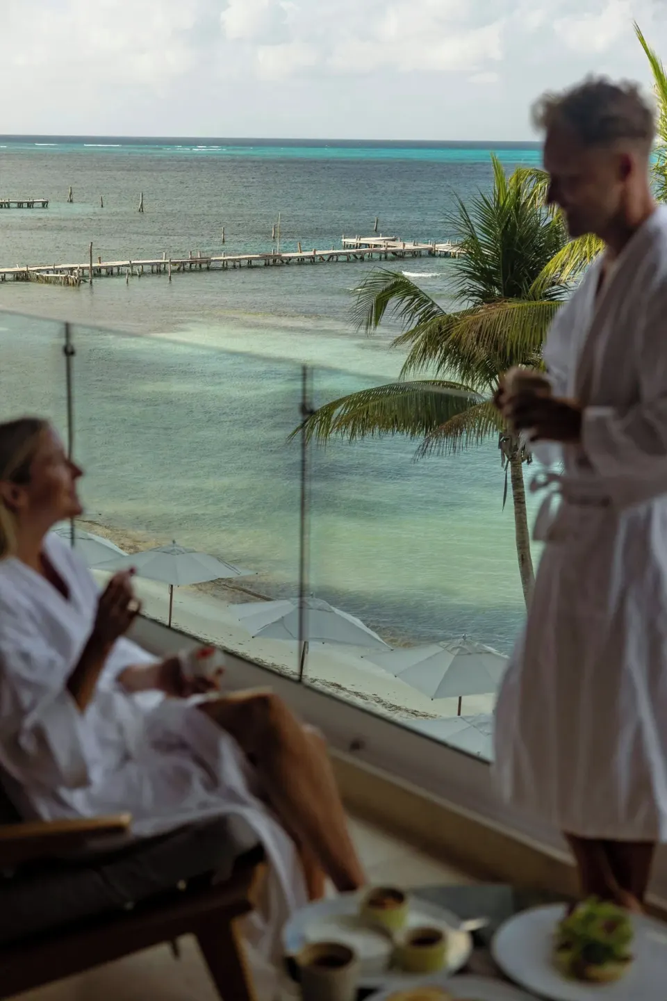 Guests in robes on a Grand Suite oceanfront balcony at Almare, a Luxury Collection Resort, Isla Mujeres.