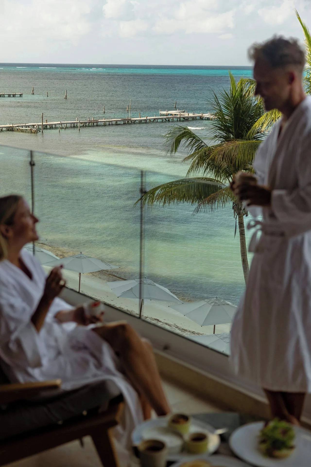 Guests in robes on a Grand Suite oceanfront balcony at Almare, a Luxury Collection Resort, Isla Mujeres.