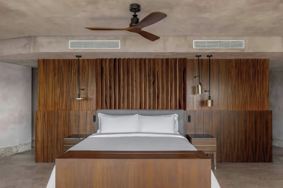 Grand Suite king bed and wood headboard wall at Almare, a Luxury Collection Resort, Isla Mujeres.