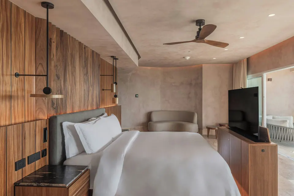 Grand Suite king bed with TV and balcony doorway at Almare, a Luxury Collection Resort, Isla Mujeres.