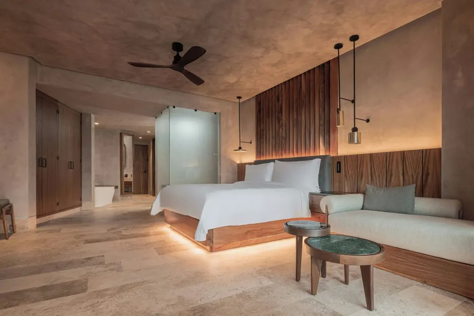 Junior Suite king bed, sofa, and open bath area at Almare, a Luxury Collection Resort, Isla Mujeres.
