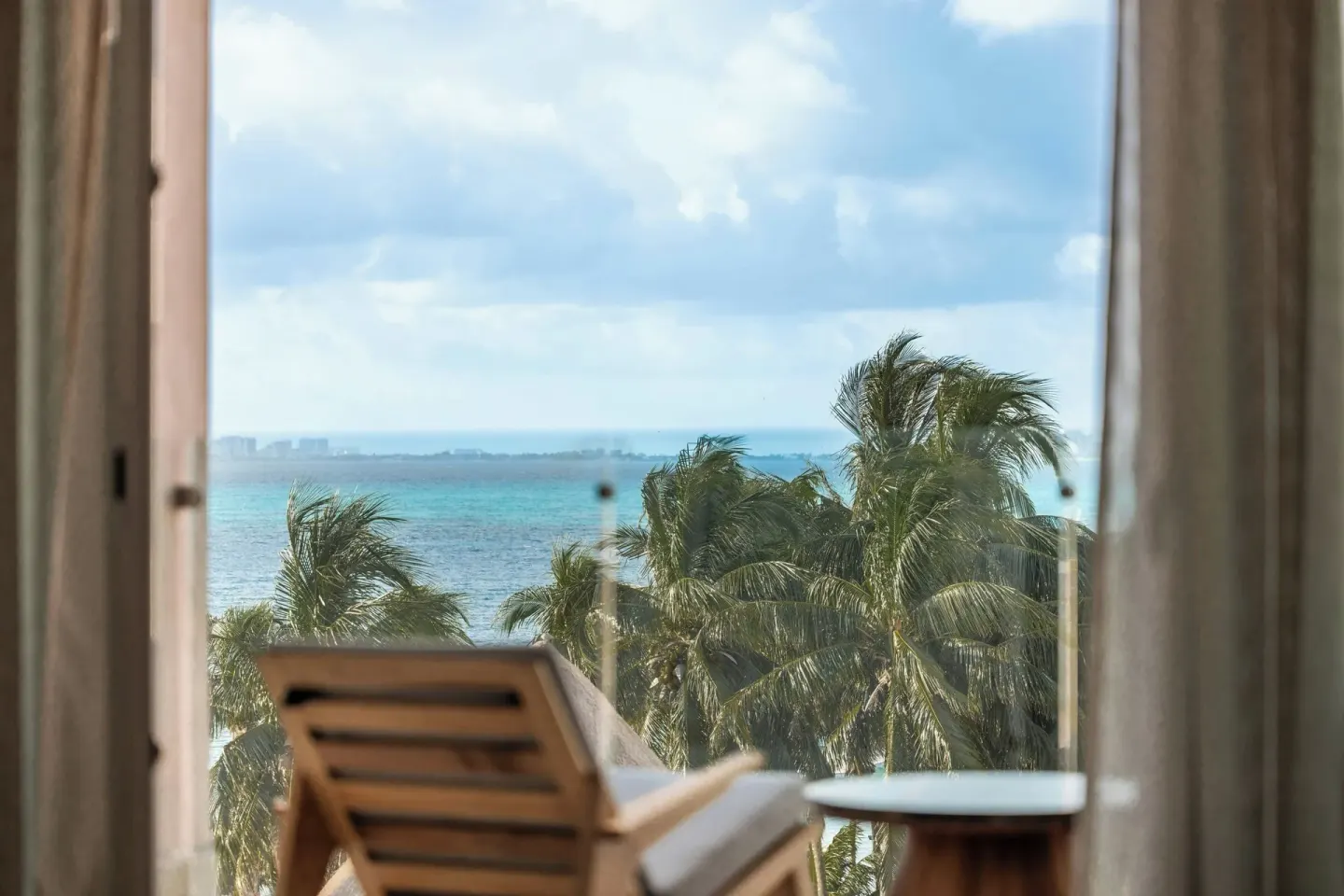 Junior Suite balcony chair with ocean and palm view at Almare, a Luxury Collection Resort, Isla Mujeres.