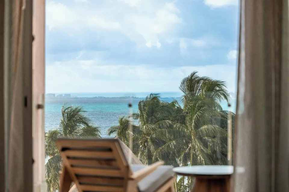 Junior Suite balcony chair with ocean and palm view at Almare, a Luxury Collection Resort, Isla Mujeres.