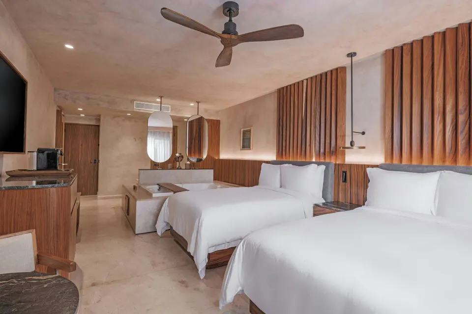 Standard Room Balcony with two beds, ceiling fan, and vanity mirrors at Almare, Isla Mujeres.