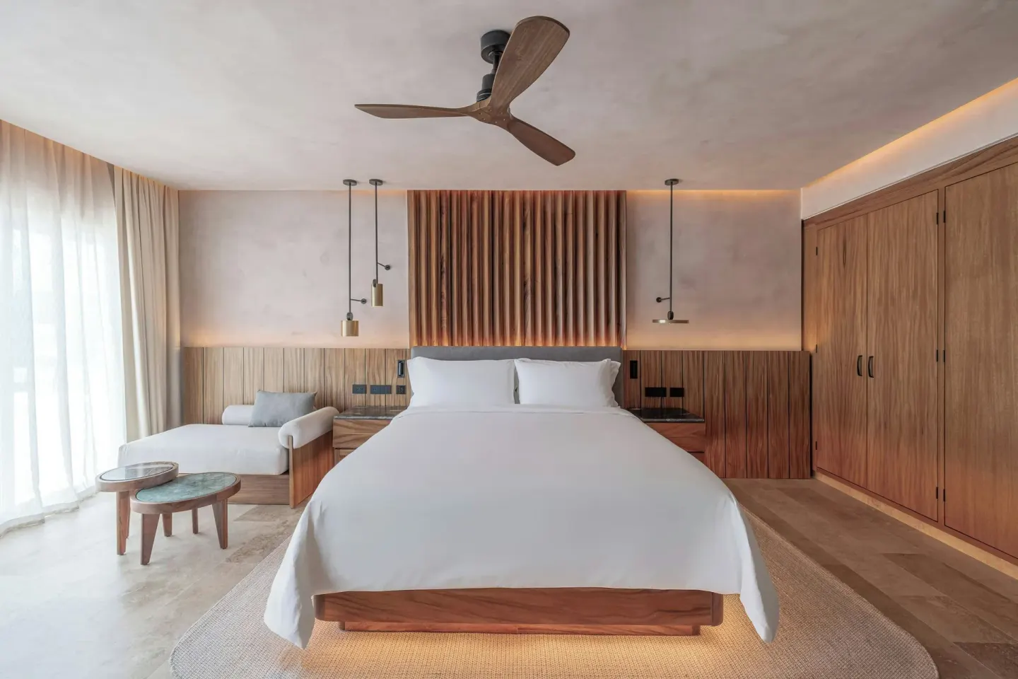 King bed with wood wardrobes and lounge chair at Almare, a Luxury Collection Resort, Isla Mujeres.