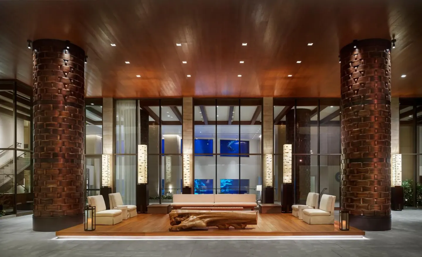 Covered lobby terrace with sofas and woven columns at 'Alohilani Resort Waikiki Beach.